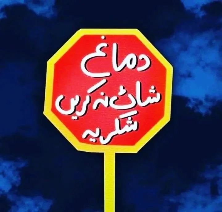 Red and yellow Urdu stop sign photographed against a deep blue sky