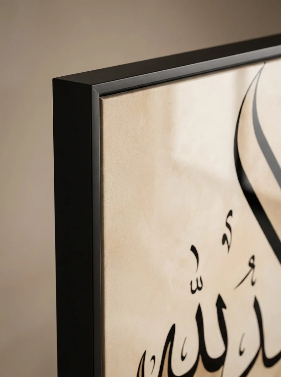 Close-up macro detail of Alhamdulillah black frame edge and canvas texture