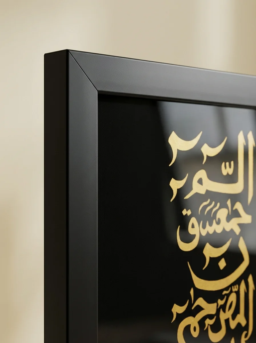 Close-up corner macro of Alif Laam Meem gold calligraphy and matte black frame